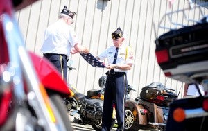 Bill Goette, left, and Dave Olson, of the American Legion Post 56, fold an American flag on Monday at Bergdale Harley Davidson. The flag, which is being escorted on the Nation of Patriots Tour, was put on display for the day before it was escorted by the Albert Lea Harley Owners Group to Waukon, Iowa.