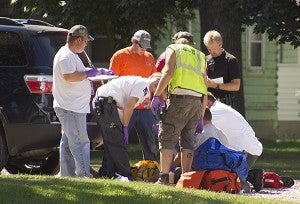 Gold Cross paramedics and other emergency responders take care of a child who was hit by a car at 208 E. Main St. in Clarks Grove Thursday afternoon. -- Sarah Stultz/Albert Lea Tribune      
