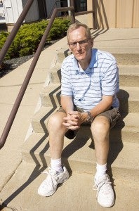 Stan Aske, a Cedar Valley Services employee, sits on the front steps of the business Friday afternoon. 