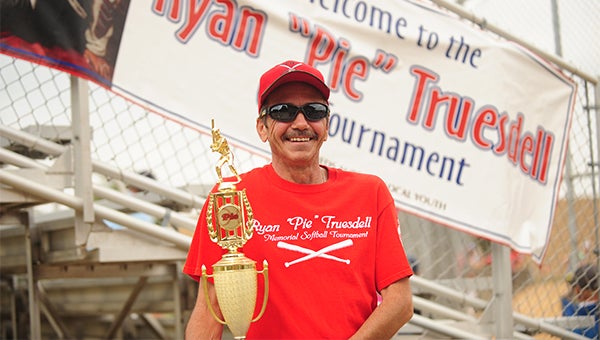 Scott Truesdell holds the Ryan "Pie" Truesdell Memorial Softball Tournament first-place trophy Sunday before awarding it to M.I.A./Combat. Scott is Ryan's father. — Micah Bader/Albert Lea Tribune