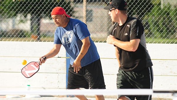 Ray Talamantes, left, volleys the ball back to the other side of the net while and Drew Wescott looks on as the duo plays pickleball doubles at Academy Park. Participation in Albert Lea has increased from five players last year to 40 this year. — Micah Bader/Albert Lea Tribune