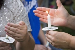 Participants at a memorial service at Central Park Tuesday light candles for World Suicide Prevention Day. 