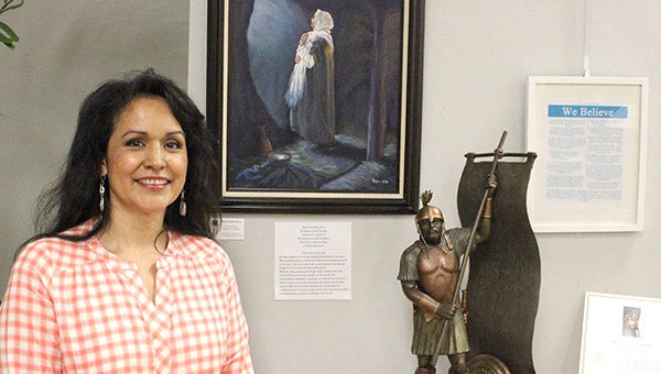 Dora Thomas poses for a photo next to a painting she created. The painting, the sculpture next to it and a few other pieces are on display at the art center on loan from The Church of Jesus Christ of Latter-day Saints. --Kelli Lageson/Albert Lea Tribune