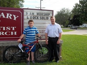 John Hinderscheit, left, accepts a bike from the Rev. Clayton Balsley. --Submitted