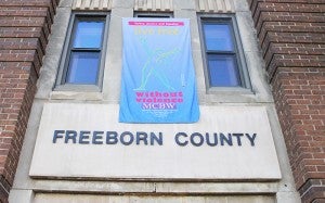 A banner for the Live Violence Free Flag Campaign hangs on the Freeborn County Department of Human Services building on Monday on Clark Street. The banner will be hung after each domestic violence homicide in the state. --Sarah Stultz/Albert Lea Tribune