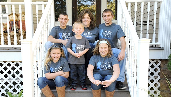 Sporting T-shirts that say “No one fights alone!” the family of Doug Herr sits on their front porch Friday afternoon. Front left is Addison, Michael, Nathan, Brenda, Mason and Makenzie. Herr passed away from State 4 esophageal cancer on Friday. -- Brandi Hagen/Albert Lea Tribune