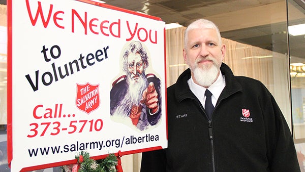 Albert Lea Salvation Army Capt. Jim Brickson on Monday stands next to a sign asking for bell ringers at North Bridge Mall. Brickson is attempting to break a world record the first week in December by ringing more than 80 consecutive hours. -- Sarah Stultz/Albert Lea Tribune