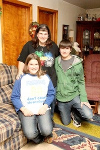 Ryan Lacher, right, stands with his mother, Michelle, and sister, Taylor, in his grandmother’s home on Friday. -- Brandi Hagen/Albert Lea Tribune