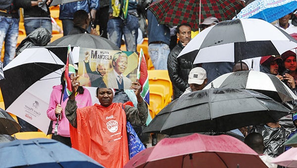 People attend the memorial service for Nelson Mandela today in Johannesburg as more than 100 world leaders gathered in the rain with tens of thousands of mourners. -- Xinhua Zhang Chen/MCT