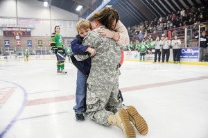 U.S. Army Staff Sgt. William Hood hugs his son, 5-year-old Dylan, after he surprised him and wife Ashley at center ice Friday night at Riverside Arena. -- Eric Johnson/Albert Lea Tribune