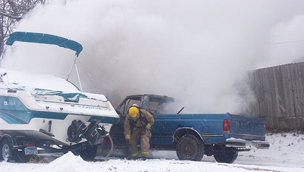 A blue Ford pickup caught fire Saturday morning in an alley behind College Street in Albert Lea while snow fell. Albert Lea firefighters responded and doused the fire. -- Tom Jones/ for the Albert Lea Tribune