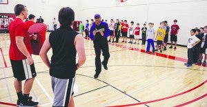 Former Minnesota Viking Carl Lee tells Sam Johnson, 13, what he did right in a drill Saturday morning during a camp put on by Lee and Chuck Foreman at Ellis Middle School.
