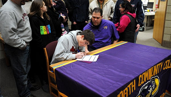Jonathan Fleek, the starting shortstop on the Albert Lea baseball team, sits next to Ellsworth Community College baseball head coach Travis Akre Wednesday as he signs a letter of intent to play baseball for the Panthers in Iowa Falls, Iowa. — Micah Bader/Albert Lea Tribune    