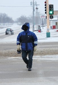 Joseph Madrigal crosses West Main Street at the First Avenue intersection Thursday, heading north. Covering the face made the difference when heading into the strong northwest wind. --Tim Engstrom/Albert Lea Tribune