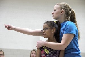 First grade teacher Jennifer Anderson helps a student line up during dance practice.  The dance club ends each day by performing for students and parents.