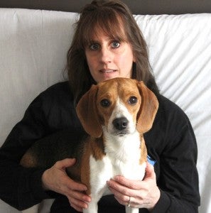 Cindy Rettke sits with Abby, a beagle that goes to Staycation Pet Care. 