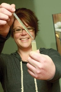 Sara McGuire fills a chapstick tube.
