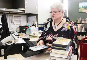 Gail Rasmussen checks in DVDs and books last week in the Albert Lea Public Library. --Sarah Stultz/Albert Lea Tribune 