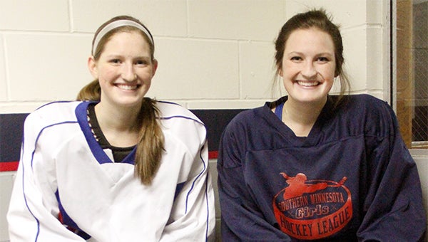 Sisters Hannah, left, and Sarah Savelkoul sit outside the Tigers’ locker room at Albert Lea City Arena before practice on Tuesday. — Drew Claussen/Albert Lea Tribune