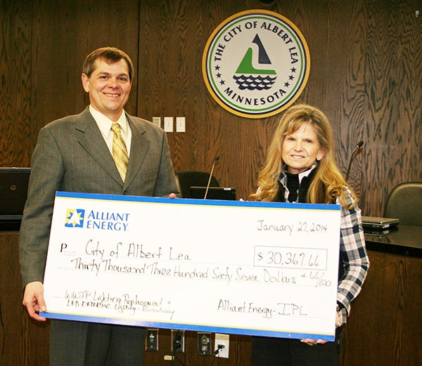 Rebecca Gisel, of Alliant Energy, presents the Albert Lea Mayor Vern Rasmussen with a check for $30,367 for rebates earned at an Albert Lea City Council meeting in January. The city's wastewater treatment plant replaced its T-12 flourescent fixtures with T-8 fixtures and also fitted its exit signs with LED lights. Alliant Energy’s rebate reimbursed the city for 200 percent of the first year’s cost savings, which equaled $29,847. An additional $520 in rebates was added for using LED lighting on Broadway. Gisel also presented the Council with a check from the Alliant Energy Foundation in the amount of $5,250 to go toward iron benches that would fit the historical character of the downtown area. The foundation is solely funded by Alliant Energy shareholders to provide positive differences in the communities where Alliant Energy has employees, retirees and customers that live and work in the community. -- Submitted 