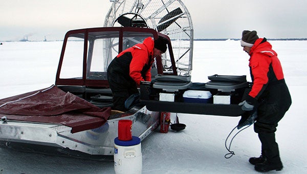 Bob Hanko, left, and Ed Swartz, both from Huron, Ohio, unload gear from an airboat on Saginaw Bay of Lake Huron. Hanko designed the craft for ice fishing and rescue work on the Great Lakes and other northern waters. -- Eric Sharp/Detroit Free Press