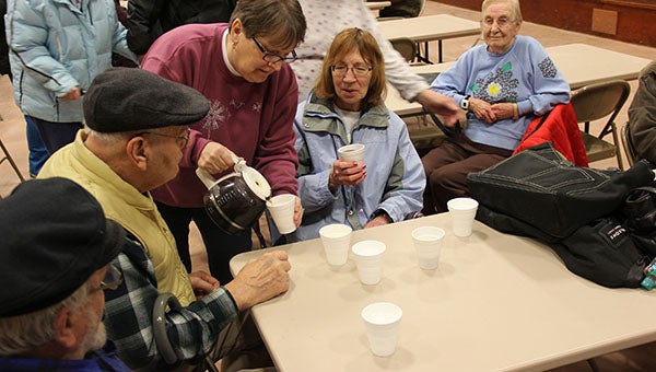 Jane Ritzert of Kensett, Iowa, pours coffee Thursday at the Kensett Community Center, a former school gymnasium. The people gathering there were evacuated from their homes in Northwood, Iowa, six miles to the north. -- Tim Engstrom/Albert Lea Tribune