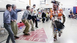   Reuben Crowfeather of Prior Lake, right, laughs as some of the male teachers at Sibley Elementary practice some of the dances that Larry Yazzie and the Native Pride Dancers presented Wednesday. --Sarah Stultz/Albert Lea Tribune 