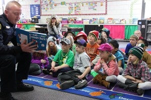Albert Lea Police Department Lt. Darin Palmer reads "The Cat in the Hat Comes Back" by Dr. Seuss to children in second-grade teacher Beth Faber's class Monday at Sibley Elementary School.