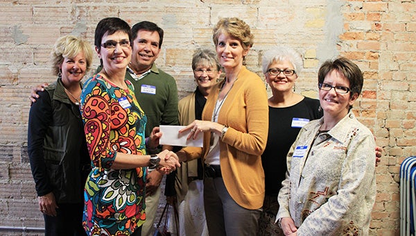 Freeborn County Communities Foundation chairwoman Jill Peterson, middle, shakes hands with Mary Laeger-Hagemeister and other member of the Taste of Heritage committee. -- Submitted