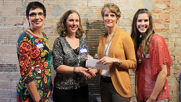 Freeborn County Communities Foundation chairwoman Jill Peterson, center, shakes hands with people from the United Way. 