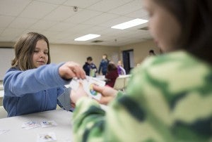 Ten-year-old Isabelle Wegner plays cards with her 8-year-old sister Olivia during the Terrific Tuesday daycamp put on by Albert Lea Parks and Recreation on Tuesday at City Arena. – Colleen Harrison/Albert Lea Tribune