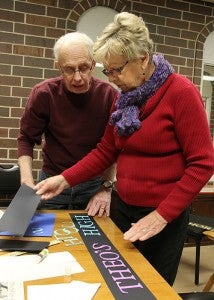 Tom Mullen and Darlyne Paulson create signs to label the student art Friday that will be on display at the Albert Lea Art Center beginning Sunday. -- Sarah Stultz/Albert Lea Tribune