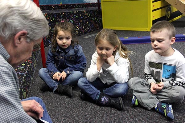 Darryl Meyer, lieutenant governor for Region 6 Kiwanis clubs, reads a story at The Children’s Center on Thursday. From left, Danika Talamantes, Ava Wangsness and Graham Goskeson listen to the story. – Tiffany Krupke/Albert Lea Tribune