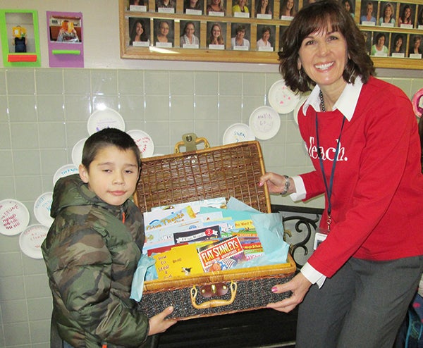 First-grade student, Corbin Pathammavong, wins a basket of books during Hawthorne Elementary School’s “Muffins and More” breakfast. Family members were invited into the school to have breakfast and see the students’ work. – Submitted