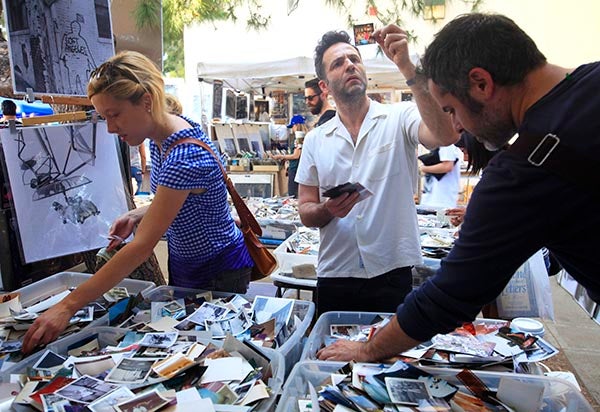 People sift through photos at a Los Angeles flea market. – MCT
