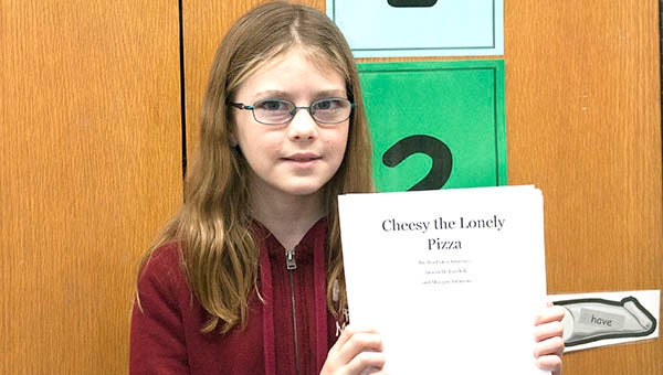 Ava Corey-Gruenes holds up her story, “Cheesy the Lonely Pizza.” Corey-Gruenes, a fourth grader at Lakeview Elementary, is also writing her own book. --Tiffany Krupke/Albert Lea Tribune