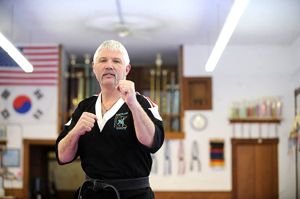 Dana Nelson, a co-owner of Northland Karate, gets in his stance in front of numerous trophies and medals at the Albert Lea dojang. – Micah Bader/Albert Lea Tribune