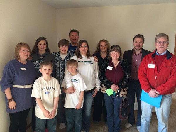 Members of Habitat for Humanity pose for a photo with the Klabunde and Christianson family. A dedication ceremony was held for the family’s new home in Lyle that was recently finished. – Submitted
