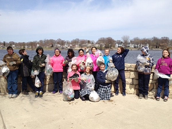 St. Theodore Catholic School students collect litter by the bandshell in Edgewater Park. – Submitted
