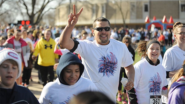 Josh Talamantes, middle, waves while running next to Brooke Talamantes Saturday at the start of Southwest Middle School’s eighth-annual Tiger Trot. — Micah Bader/Albert Lea Tribune
