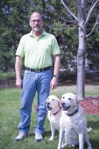 Recently retired detective supervisor Chuck Malepsy poses for a photo with his dogs Dakota and Trigger outside of his Albert Lea home. Malepsy retired from the Freeborn County Sheriff’s Office after more than 30 years of service. – Colleen Harrison/Albert Lea Tribune
