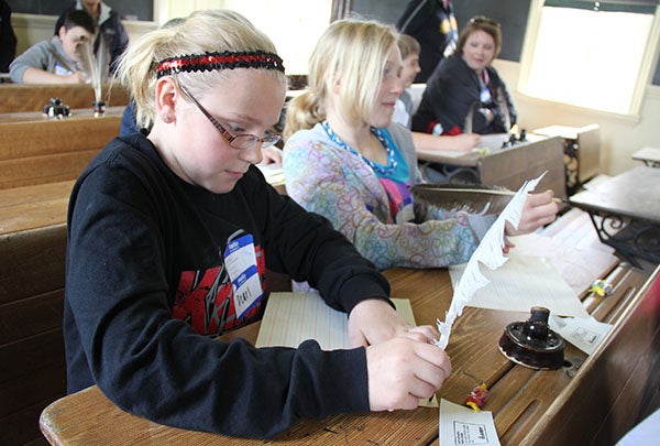 Kaylee Wachlin, left, and Abbie Theusch practice writing with quills on Wednesday in the schoolhouse of the Freeborn County Historical Museum, Library & Village. – Sarah Stultz/Albert Lea Tribune