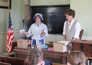 Albert Lea High School juniors Lexi Gordon and Matt Carlson teach about life in a school during the 1800s during Discover History Days at the Freeborn County Historical Museum, Library & Village. – Sarah Stultz/Albert Lea Tribune