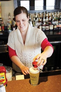 Skol Tavern Assistant Manager Nicole Thompson plops a shot of raspberry liqueur into a Leinenkugel’s Summer Shandy beer to create a raspberry boiler. Behind her are some of the bar’s wide selection of whiskeys.