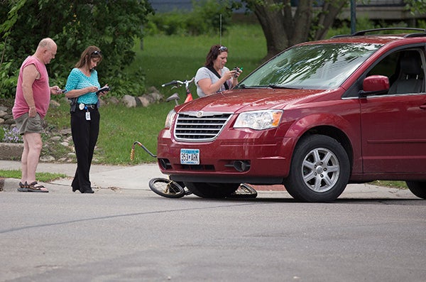 A red minivan and a young bicyclist collided at the intersection of Lincoln Avenue and West Front Street in Albert Lea around 1 p.m. Monday afternoon. – Colleen Harrison/Albert Lea Tribune