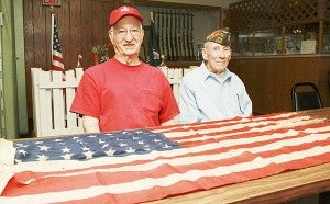 World War II veterans Truman Moen, left, and Charles Rector sit next to an American flag carried into Normandy on D-Day 70 years ago. VFW members found the flag last week when cleaning the club’s hall at 300 Fourth Ave. NE for an expansion. – Jason Schoonover/Albert Lea Tribune