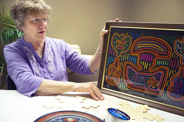Bev Jackson Cotter shows off a “mola” created by the Kuna people of Panama. This piece is an example of the things found at the Unique Junque sale. – Hannah Dillon/Albert Lea Tribune