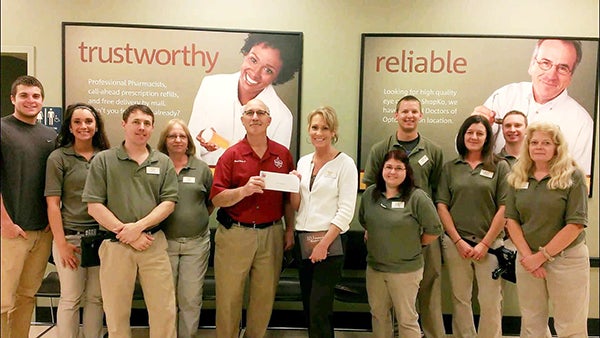 Twin Valley Council Boy Scouts of America Field Director Rene’ Maes Jr. receives a $250 check from members of Shopko. – Provided