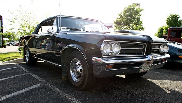 A 1964 Pontiac GTO Convertible owned by Doug Bronson gleams in the afternoon sun at the Cruise-in Social for Eddie Cochran Weekend. — Hannah Dillon/Albert Lea Tribune