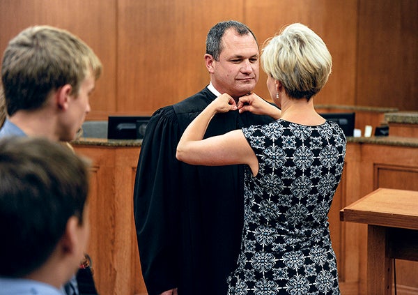 Tammy Kritzer cinches the robes of her husband Jeff who was sworn in as a Mower County judge Friday afternoon at the Jail and Justice Center. — Eric Johnson/Albert Lea Tribune